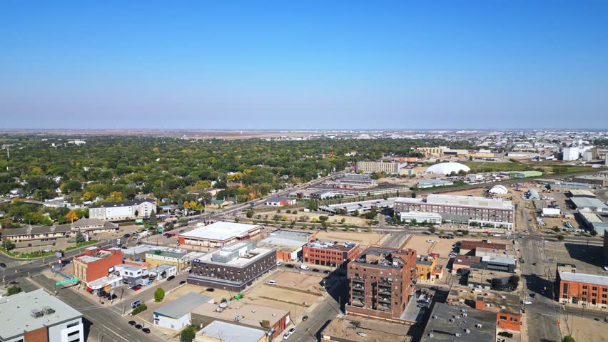 Slow aerial pan of Saskatoon in fall, deep blue sky, older district, parks