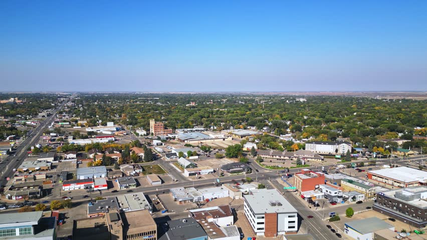 Aerial pan across old Saskatoon district with main road, homes, small shops