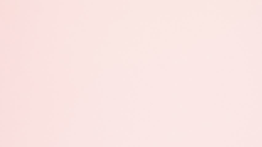 Blue crumpled paper unfolds then refolds on pink in stop motion transition