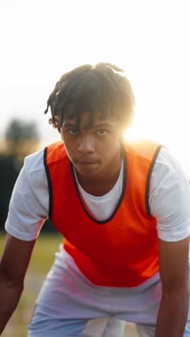 Athletic teen boy training alone outdoors, vertical portrait of young basketball player. Sportive hobby and active lifestyle, do sport and live healthy life, african american teen boy exercising