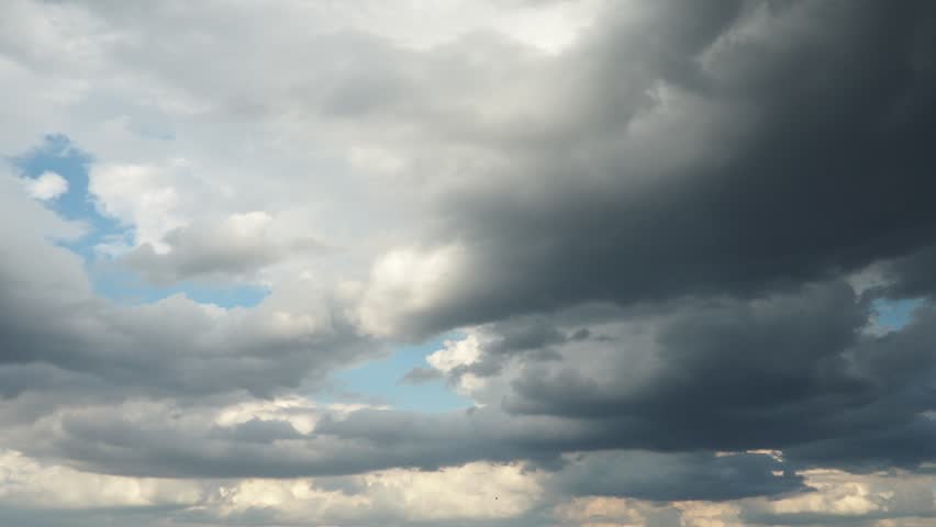 Beautiful white clouds in sky. Sunrays are hidden behind approaching dark clouds. Cumulus convection in troposphere. Cumulonimbus Sunset and sunrays. Real time slow motion video