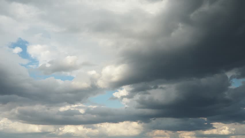 Beautiful white clouds in sky. Sunrays are hidden behind approaching dark clouds. Cumulus convection in troposphere. Cumulonimbus Sunset and sunrays. Real time slow motion video