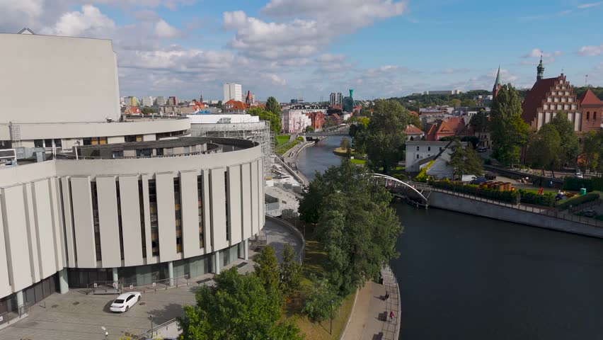 Aerial view of Opera Nova by the river, with kayakers enjoying the water in the vibrant city, Bydgoszcz, Kuyavian-Pomeranian Voivodeship, Poland.