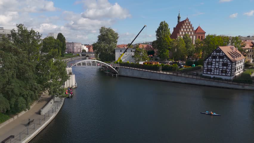 Aerial view of the Opera Nova building under construction, and footbridge over the river, with the city skyline in the distance, Bydgoszcz, Województwo kujawsko-pomorskie, Poland.