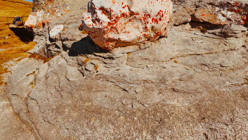Mushroom shaped and anthropomorphic rock formations in a beautiful mountain range, displaying weathered stone columns, rounded caps, and curious silhouettes, under open sky across rugged terrain
