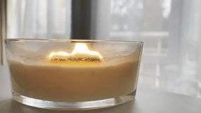 Large scented candle in glass jar burning in cozy autumn home interior, warm hygge atmosphere, aromatherapy close up - Powered by Shutterstock - Get 15% off with code: PIKWIZARD15