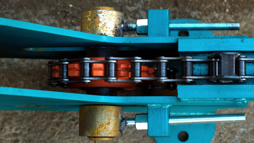 Gear wheel rotating metal chain on industrial automated equipment. Mechanism for conveyor belt line on modern woodworking metalworking factory plant. Production manufacturing in heavy industry.