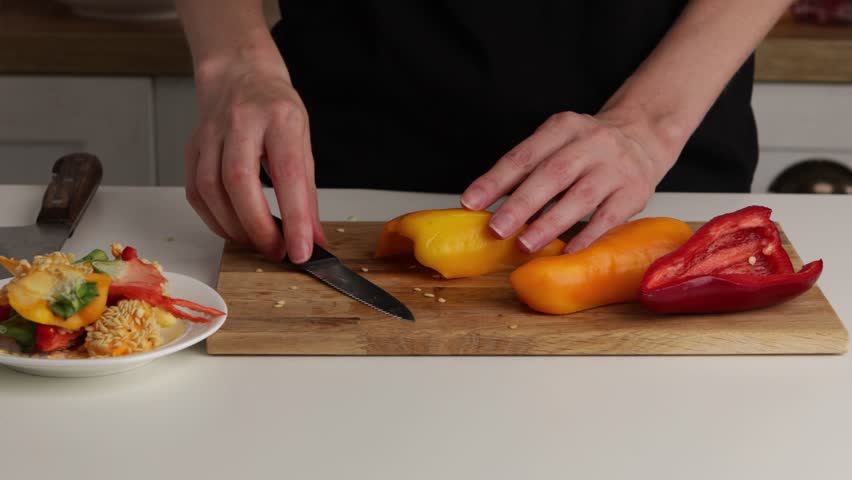 cutting red and yellow pepper on wooden board food