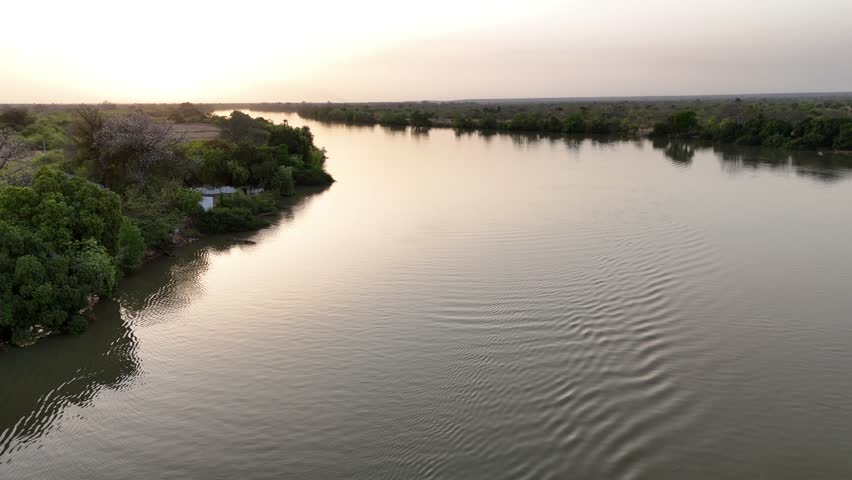 Scenic drone shot of the Gambia River at golden hour with reflections of the sky on the water