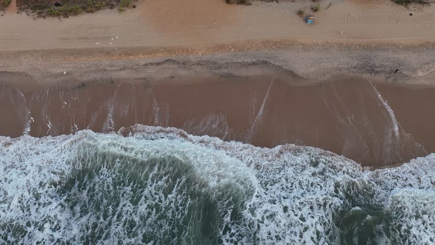 Aerial drone view of the tropical beach in Banjul, Gambia, with golden sand and powerful Atlantic waves
