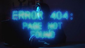 Mysterious hacker in hoodie and mask typing on laptop glowing with error 404 message in darkness. Perfect for cyber attack, data theft, and security breach themes. - Powered by Shutterstock - Get 15% off with code: PIKWIZARD15