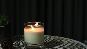 nice burning luxury aromatic scented candle glass is on marble table with a pine cone and background of grey stone curtain in bed room to create relax and romantic moment for lovers on Valentine day - Powered by Shutterstock - Get 15% off with code: PIKWIZARD15