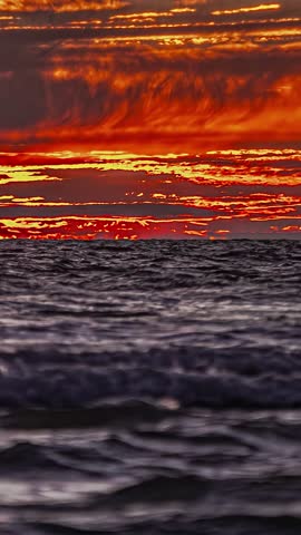 Timelapse Of Sunrise Across Fiery Sky Over Ocean - Vertical Shot
