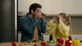 Happy Caucasian family at kitchen playing fooling having fun Caucasian child girl daughter kid with father holding cucumber slices like glasses cover eyes with vegetable circles joyful funny cooking - Powered by Shutterstock - Get 15% off with code: PIKWIZARD15