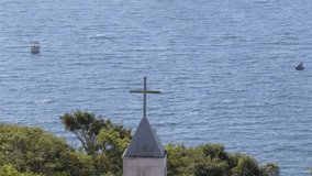 Cross of Nossa Senhora da Imaculada Conceição Chapel with Atlantic Ocean and boats in the background, Bombinhas, Brazil. - Powered by Shutterstock - Get 15% off with code: PIKWIZARD15