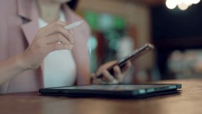 Modern smart office concept with businesswoman using stylus on tablet and checking smartwatch in colorful co-working space - Powered by Shutterstock - Get 15% off with code: PIKWIZARD15