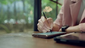 Asian professional woman multitasking with smartwatch and stylus on tablet, concept of digital career and time management - Powered by Shutterstock - Get 15% off with code: PIKWIZARD15