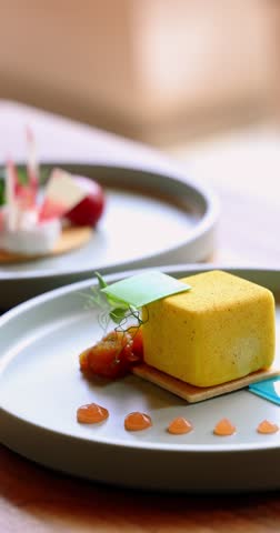Gourmet dessert on elegant plate, featuring artistic presentation of sweet treat with caramel dollops, layered pastry, and decorative elements in fine dining setting. Vertical