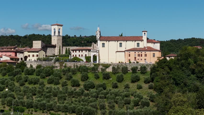 Aerial view of Chiesa Parrocchiale della Natività della Madonna and Castello di Polpenazze on Lake Garda, Italy. Historic medieval castle and fortress captured in 4K drone footage.