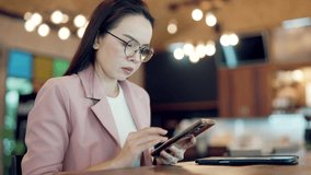 Asian businesswoman using smartphone with futuristic infographic showing global investment and performance data in a smart workspace, representing remote management, finance, and digital strategy. - Powered by Shutterstock - Get 15% off with code: PIKWIZARD15