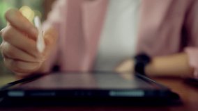 Close-up of Asian businesswoman using stylus on tablet with multiple data charts and global map dashboard overlay, representing smart analytics, business intelligence, performance tracking - Powered by Shutterstock - Get 15% off with code: PIKWIZARD15
