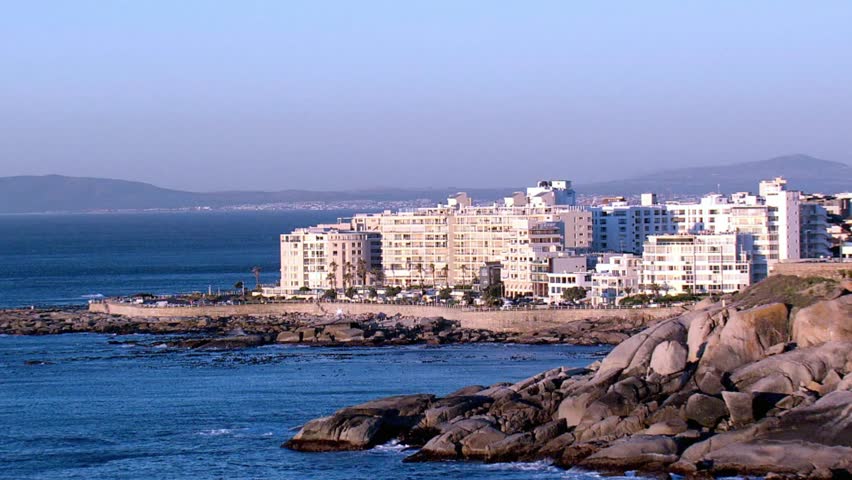Coastal buildings line the rocky shore of cape town, south africa