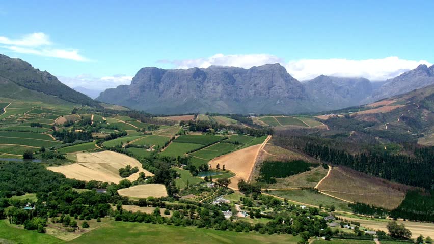 Picturesque valley with vineyards and mountains under a clear blue sky