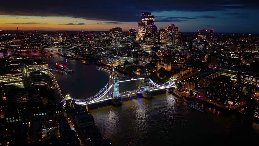 Aerial night view of the illuminated skyline of London with Tower Bridge, River Thames and City skyscrapers