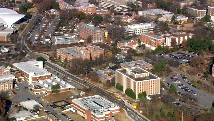 Aerial view captures the university campus with its brick buildings and parking lots