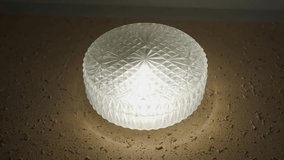 A wall lamp with a round relief shade, close-up - Powered by Shutterstock - Get 15% off with code: PIKWIZARD15