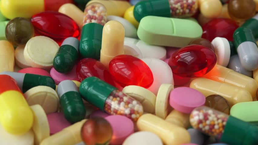 Close up of colored medical pills rotate in circle. Pills and drugs tablets. Pharmaceutical Industry. Medicine. Health care