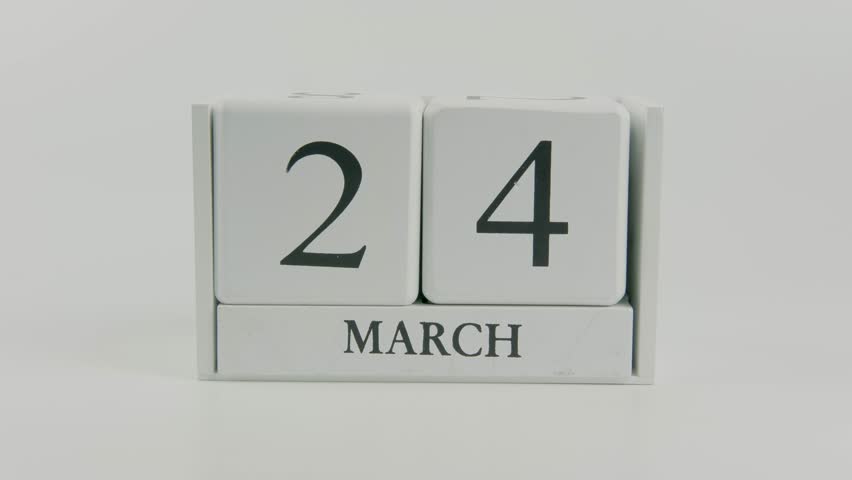 Hand flipping wooden white calendar changing date from 24 to 25 March on white background, symbolizing daily progress, routine, planning, and forward time transition