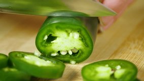 Chef Hand Cutting Green Jalapeno Pepper with Sharp Knife onto Cutting Board into Pile of Slices in Slow Motion - Powered by Shutterstock - Get 15% off with code: PIKWIZARD15