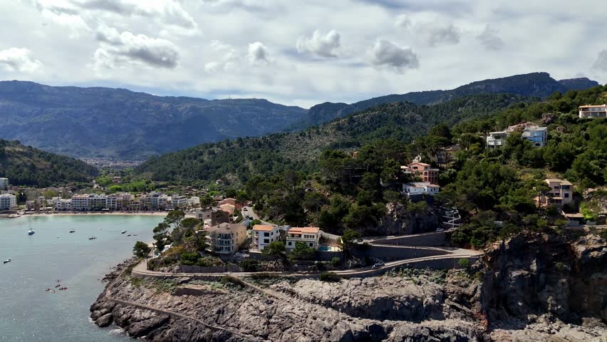 Beautiful Mediterranean scenery of Mallorca with mountains, clear blue sea, marina with yachts and a lighthouse. Perfect background for travel, tourism and vacation projects.