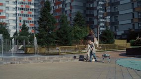 Young family with a robotic dog enjoying a walk near a fountain in a modern residential area - Powered by Shutterstock - Get 15% off with code: PIKWIZARD15