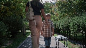 A mother and her young son walk together in a park alley with a futuristic robot dog. - Powered by Shutterstock - Get 15% off with code: PIKWIZARD15