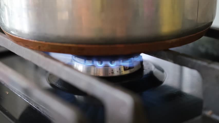 Close-up of pot on gas burner cooking food in kitchen at home