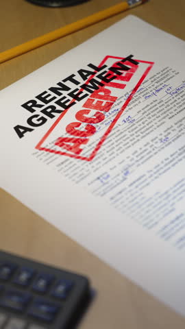 Close-up vertical view of a rental agreement form stamped with the word “ACCEPTED” in bold red letters, symbolizing approved housing applications, successful leasing, or new tenant move-in. 14843  	