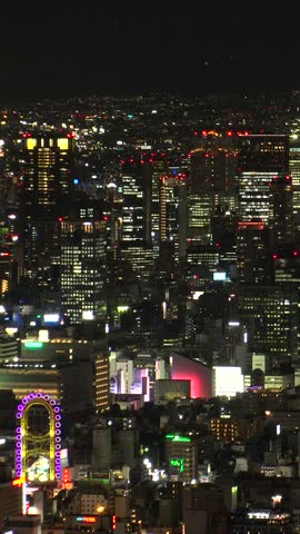 OSAKA, JAPAN : Aerial high angle view of CITYSCAPE of OSAKA at night. View of buildings and street around Namba, Shinsaibashi, Umeda and Osaka station (downtown area). Vertical shot.