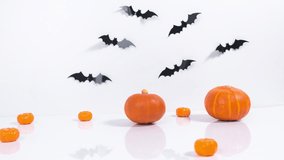 Halloween holiday concept. Greeting card. Copy space. Orange pumpkins, black bats and spider crawls on white background. Stop motion animation. - Powered by Shutterstock - Get 15% off with code: PIKWIZARD15