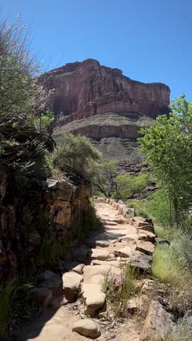 Inside the Canyon: Rocky Trail Incline with Sunlit Red Cliffs (Grand Canyon National Park, Arizona, USA)