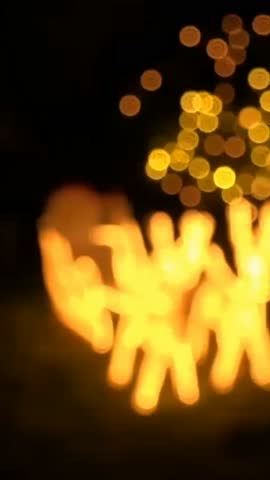 Bright fire dancers perform under the stars during a night festival in a lively outdoor setting