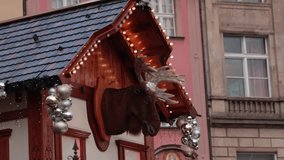 Smooth aerial video focusing on Christmas decorations with moving reindeer head on wooden house facade decorated with festive lights and silver ornaments. Holiday spirit, tradition and celebration - Powered by Shutterstock - Get 15% off with code: PIKWIZARD15