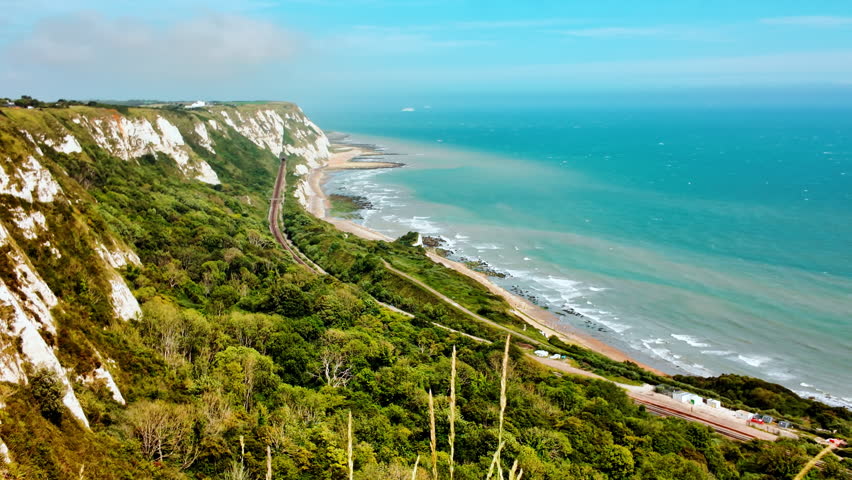 Rugged coast and railway line, Folkestone, Kent, England, UK, with chalk cliffs, sea views and tracks curving along the shoreline
