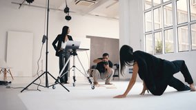 Professional creative team collaborating during stylish photoshoot, working together with camera equipment and laptop in bright modern studio environment - Powered by Shutterstock - Get 15% off with code: PIKWIZARD15