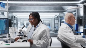 Scientist analyzing samples in laboratory setting with microscope and chemicals. Female expert advancing genetics research, combining laboratory analysis with biochemistry studies. Camera B. - Powered by Shutterstock - Get 15% off with code: PIKWIZARD15