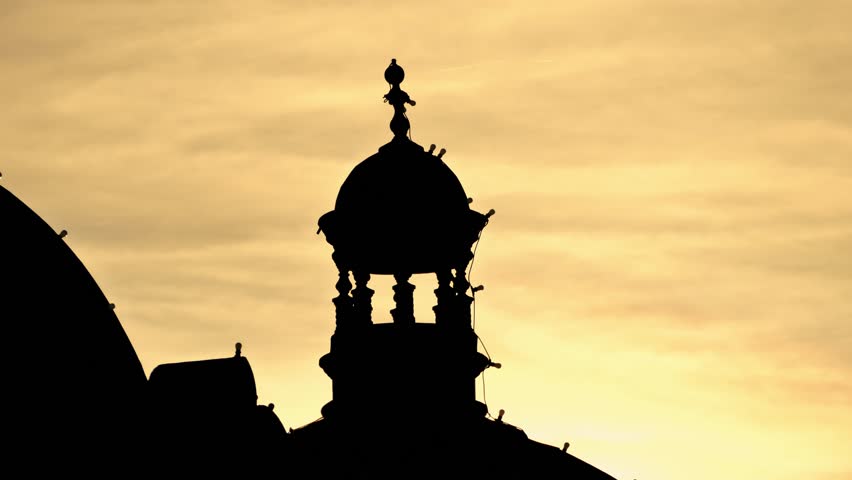 Silhouette view of British Columbia Legislative Assembly dome against a golden sunset sky