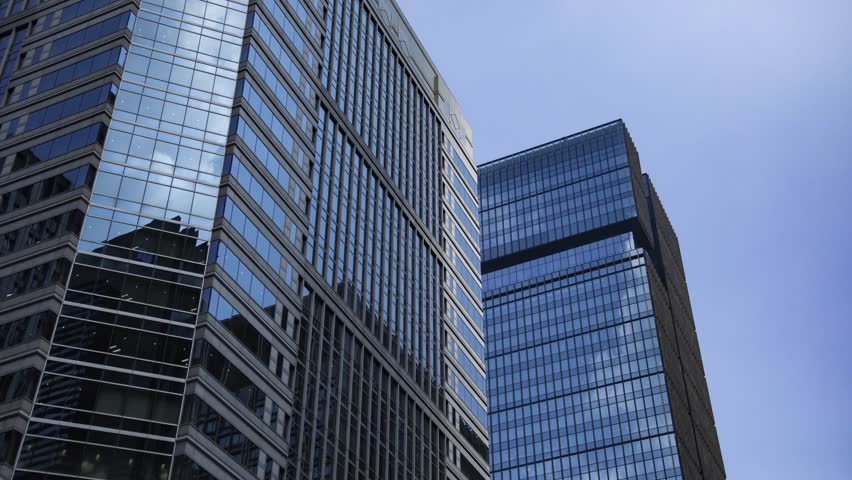 A timelapse of cloud reflecting the office building in the business town zoom