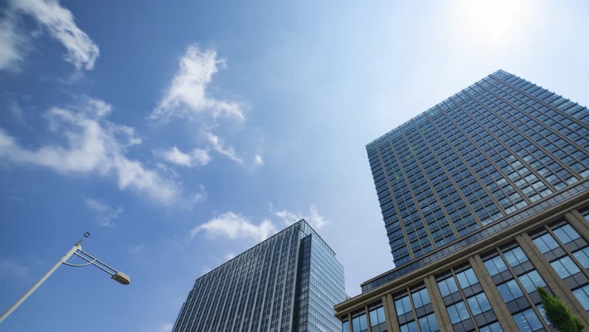 A timelapse of cloud reflecting the office building in the urban city wide shot