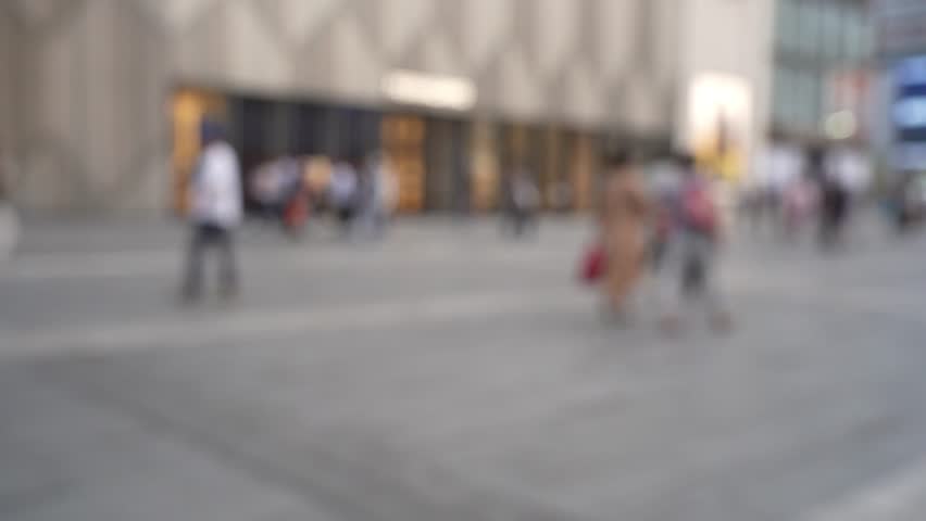 Busy street scene in Chengdu showcasing a crowd of pedestrians. The vibrant urban landscape highlights shopping areas with blurred signage and buildings. A dynamic city atmosphere